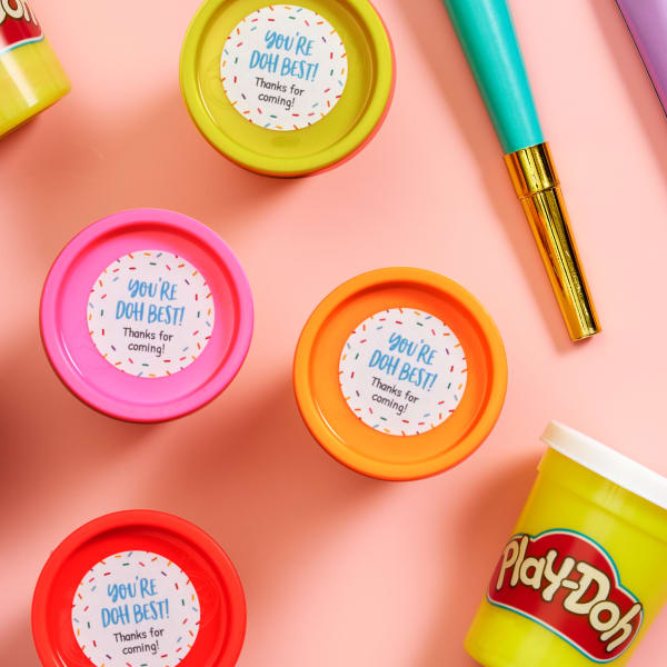 This image shows an example of a DIY party favor idea for kids made using party-sized Play Doh and Avery 1-1/2" round labels. The labels read, "You're Doh Best!" Thanks for coming!"