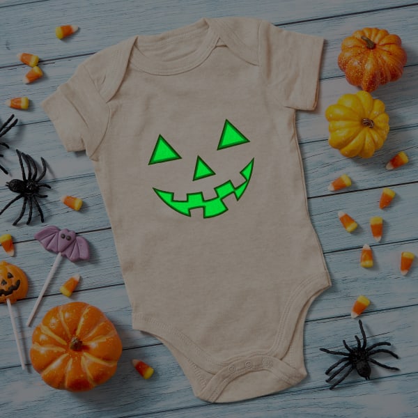 Image showing baby onesie with Halloween template of a jack-o-lantern face printed on a glow-in-the-dark fabric transfer.
