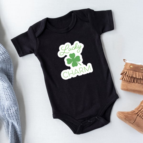 Image showing St. Patrick’s Day baby outfit with a shamrock fabric transfer design that reads “Lucky charm.”