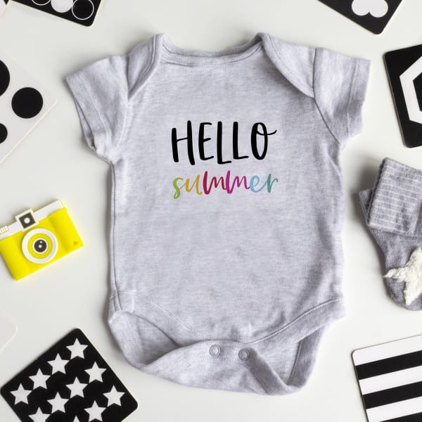 Image showing a DIY onesie made with an Avery printable fabric transfer that reads “hello summer” in colorful font.
