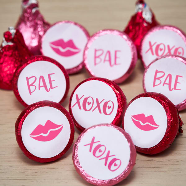 Avery 4221 3/4 inch round labels shown on pink Hershey's Kisses. The labels are printed with several pink designs including lips and the words, "BAE," and "XOXO."