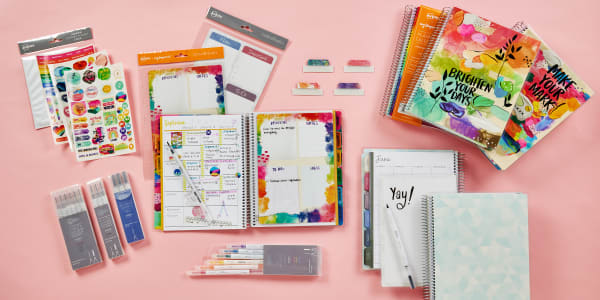 Avery planner accessories including dashboards, stickers, wet-dry erase markers, Ultra Tabs, and an adhesive corner pocket are shown laid out next to Avery teacher planners. 
