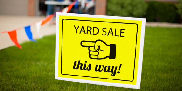 Image showing front yard with a bright yellow yard sale sign made using Avery neon label 5975 and using Avery template. Sign reads Yard Sale this way with arrow pointing to the left.