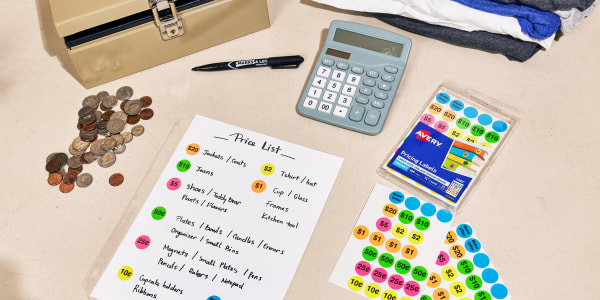 Image showing table at garage sale with money box, money, calculator, price list sheet, and Avery pricing labels.