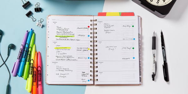 close up of a planner and avery planner supplies on a modern color blocked work surface the planner shows after work activities for helping your brain switch out of work mode that are color coded for quick and easy reference