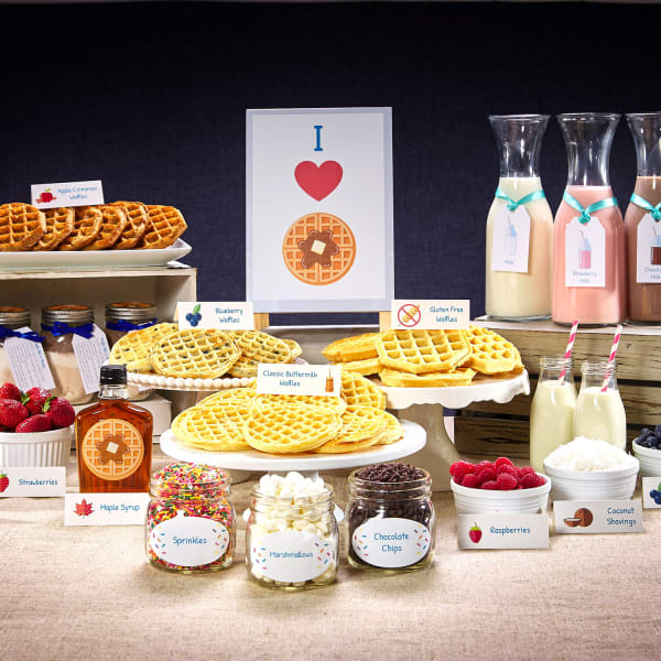 A buffet of waffles, breakfast beverages and waffle toppings is laid out for a brunch and personalized with Avery labels, tent cards, tags, and signs. 
