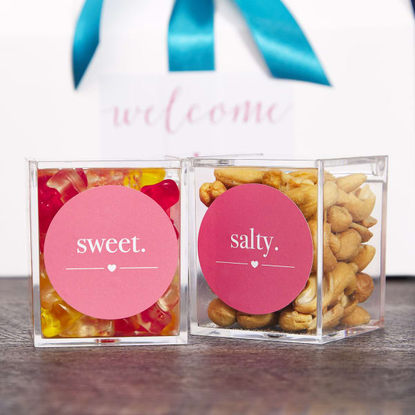 Wedding party favor examples of themed snacks. Clear boxes are filled with snacks and each box is labeled with Avery 22807 round labels personalized with the wedding colors.