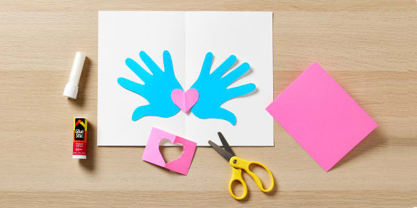 diy valentines cards step showing how to assemble hands cut out using glue stick to stick them in a blank avery card