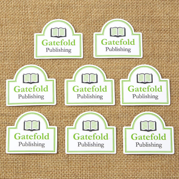 Eight Avery die-cut vinyl stickers with a company logo on them are laid out on a rustic burlap background. 