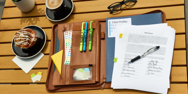 Outdoor wooden coffee shop table with a DIY work from home writing station. Leather padfolio is stocked with Avery office supplies including hi-liters, an eGel pen, Ultra Tabs and color-coding dots.