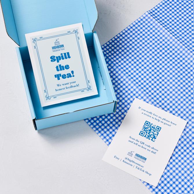 A packaging setup featuring a double-sided postcard. One side of the postcard reads "Spill the Tea! We want your honest feedback!" in blue text with decorative borders. The other side encourages customers to leave a review with the message: "If you really love us, please leave a review to help us grow!" and includes a QR code for feedback. The postcard also lists the store's social media handle and platforms: Etsy, Amazon, and TikTok Shop. The postcard is displayed in a blue box with a blue gingham cloth nearby.