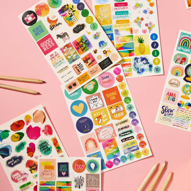 Avery + Amy Tangerine 6782 planner sticker pack sheets are shown on a pink background. The stickers are super colorful in a rainbow palette and feature positive, upbeat messages. 