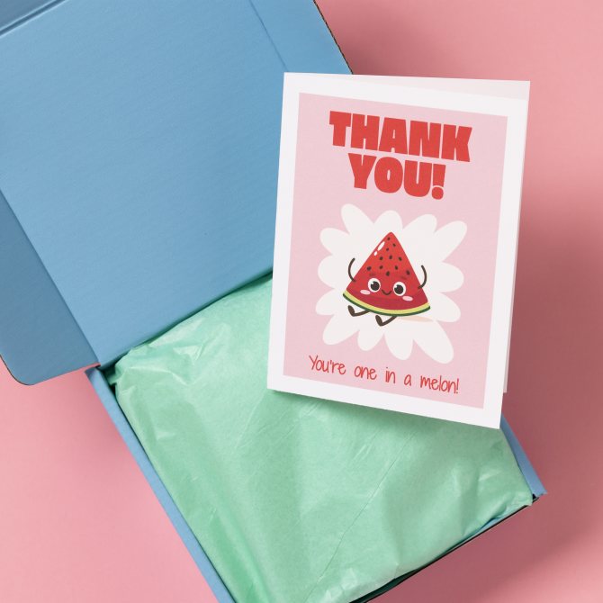 A blue box with green tissue paper lining and an Etsy thank-you card displayed on top. The card features a cute illustration of a smiling watermelon slice with the text 'THANK YOU!' in bold red letters above it and 'You're one in a melon!' below it.