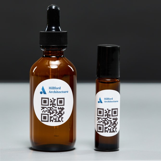 Glass apothecary product bottles with a QR code and a company logo printed on Avery round labels 8293.