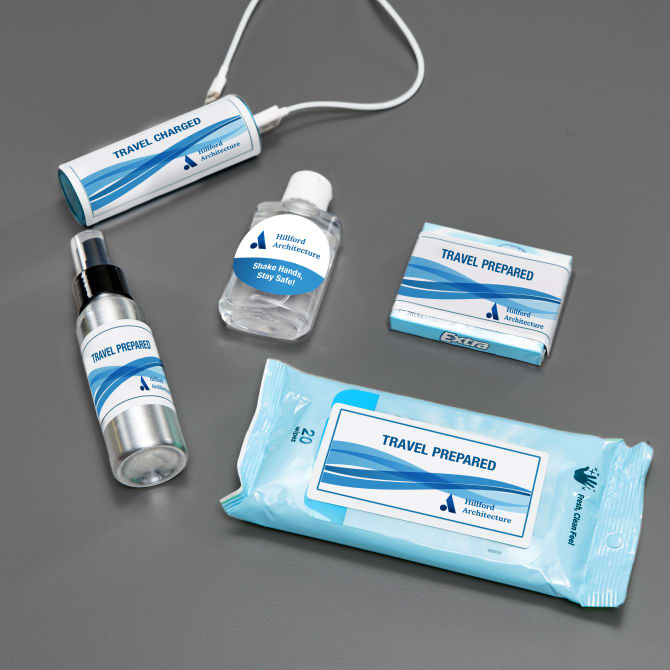 A mini travel kit idea for swag bags. The items inside have custom labels with a company logo and travel themed phrases. 