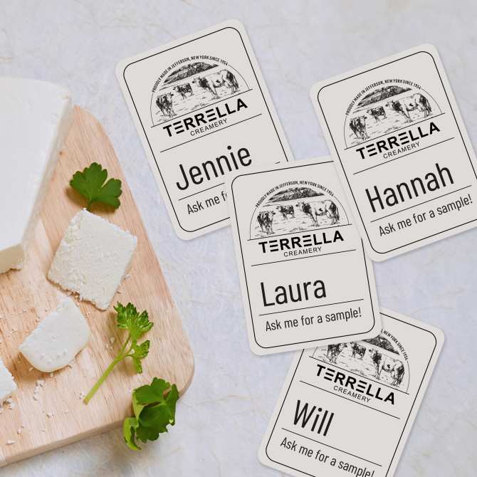 Image showing custom-designed Avery name tags for farmers market employees, with the phrase "Ask me for a sample!" displayed next to a cutting board with cheese and parsley,