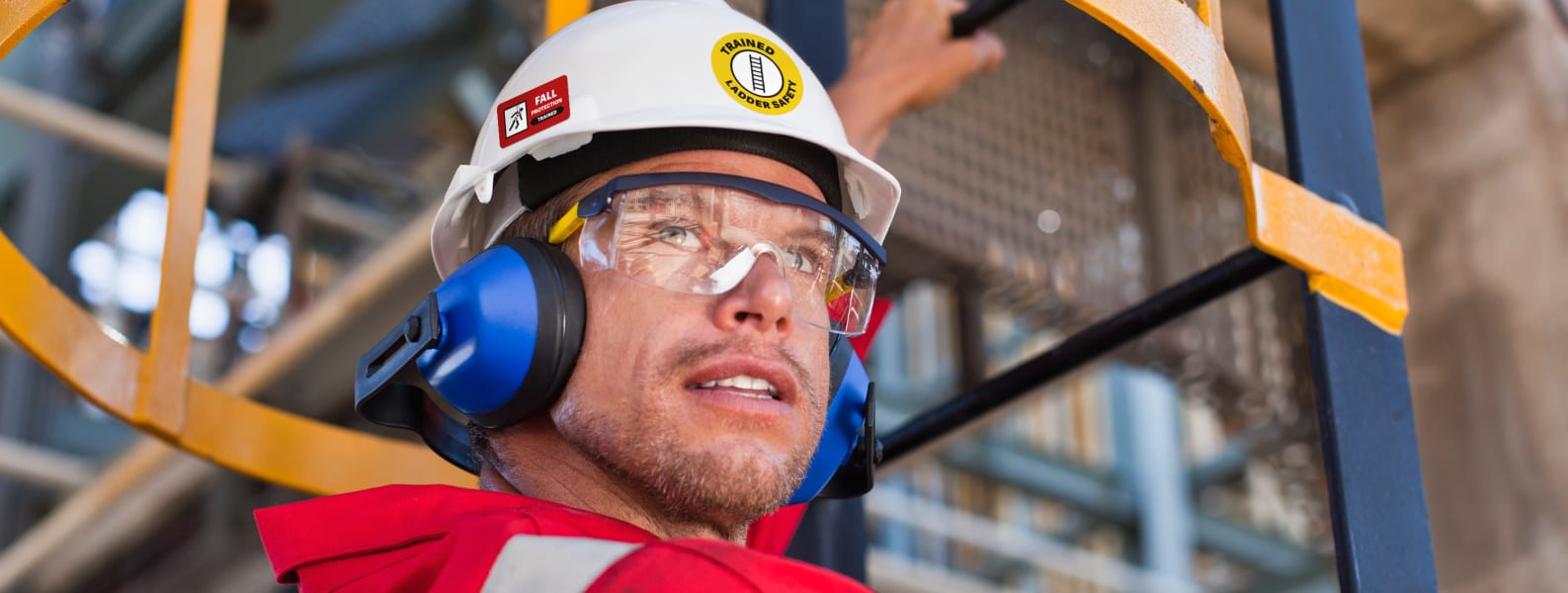 worker wearing a white hard hat, which has various hard hat stickers applied on its sides