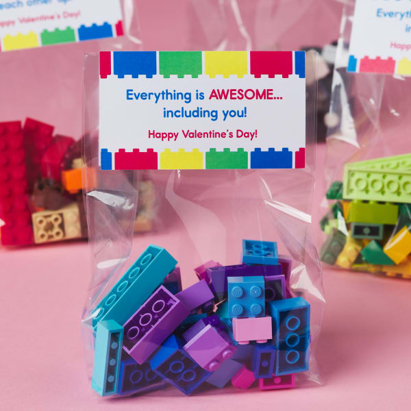 small bag filled with colorful toy building bricks and blocks topped with card reading, 'everything is awesome, including you - Happy Valentine's Day'