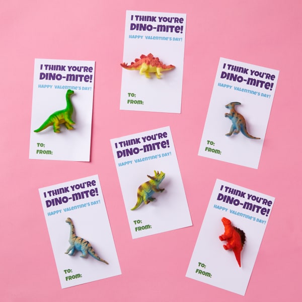 various small toy dinosaurs fastened to thick card reading, 'I think you're dino-mite - Happy Valentine's Day,' in colorful fonts