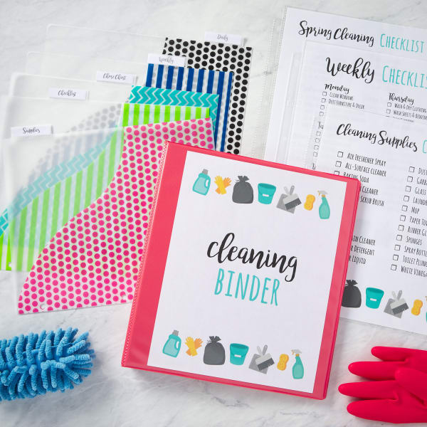 colorful cleaning schedule binder cleaning checklists dividers and cleaning supplies arranged artistically on a marble countertop