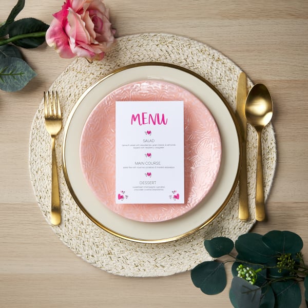 pretty gold cream and pink table setting with <strong>galentines day</strong> menu card a pink rose and greenery on blonde wooden table