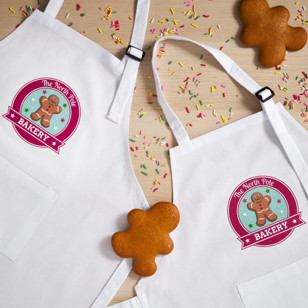 Apron party favors are shown with a personalized "North Pole Bakery" design printed on Avery 3271 iron-on fabric transfers. 