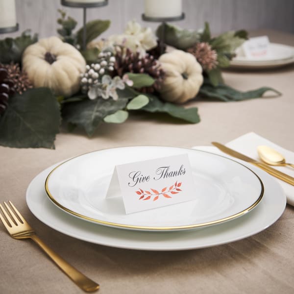 plate and cutlery topped with Thanksgiving tent card with name