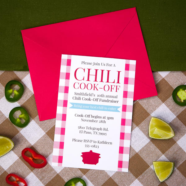 Chili cook off invitation on bright red envelope next to jalapeños and limes