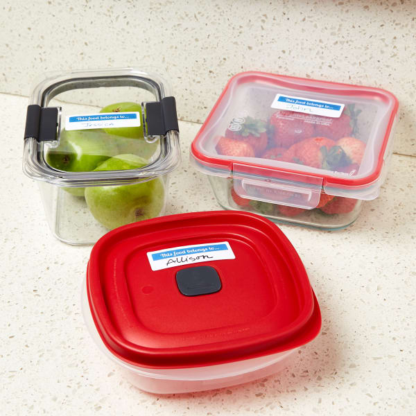 apples and strawberries in employee lunch containers with avery labels on a white and grey kitchen counter