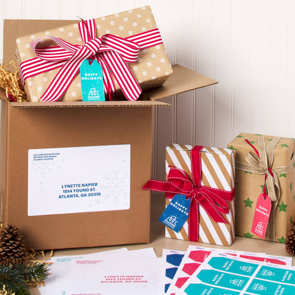 avery holiday address labels for shipping on a cardboard box with holiday accents arranged artistically on a table