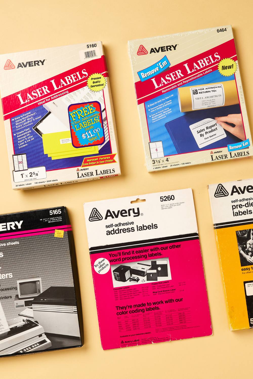 The image showcases a collection of vintage Avery label packaging, representing different moments in the history of labels. It includes various types of laser and self-adhesive address labels. The top left box is for Avery 5160 Laser Labels, featuring a bright red banner and a promotional offer for free labels. To the right is the Avery 6464 Remove 'Em Laser Labels, designed for removable and repositionable use. The bottom section shows Avery 5165 full sheet labels in a black box, and Avery 5260 self-adhesive address labels, highlighting ease of use with word processing systems. These products reflect the evolution of labels in office and personal use over time.