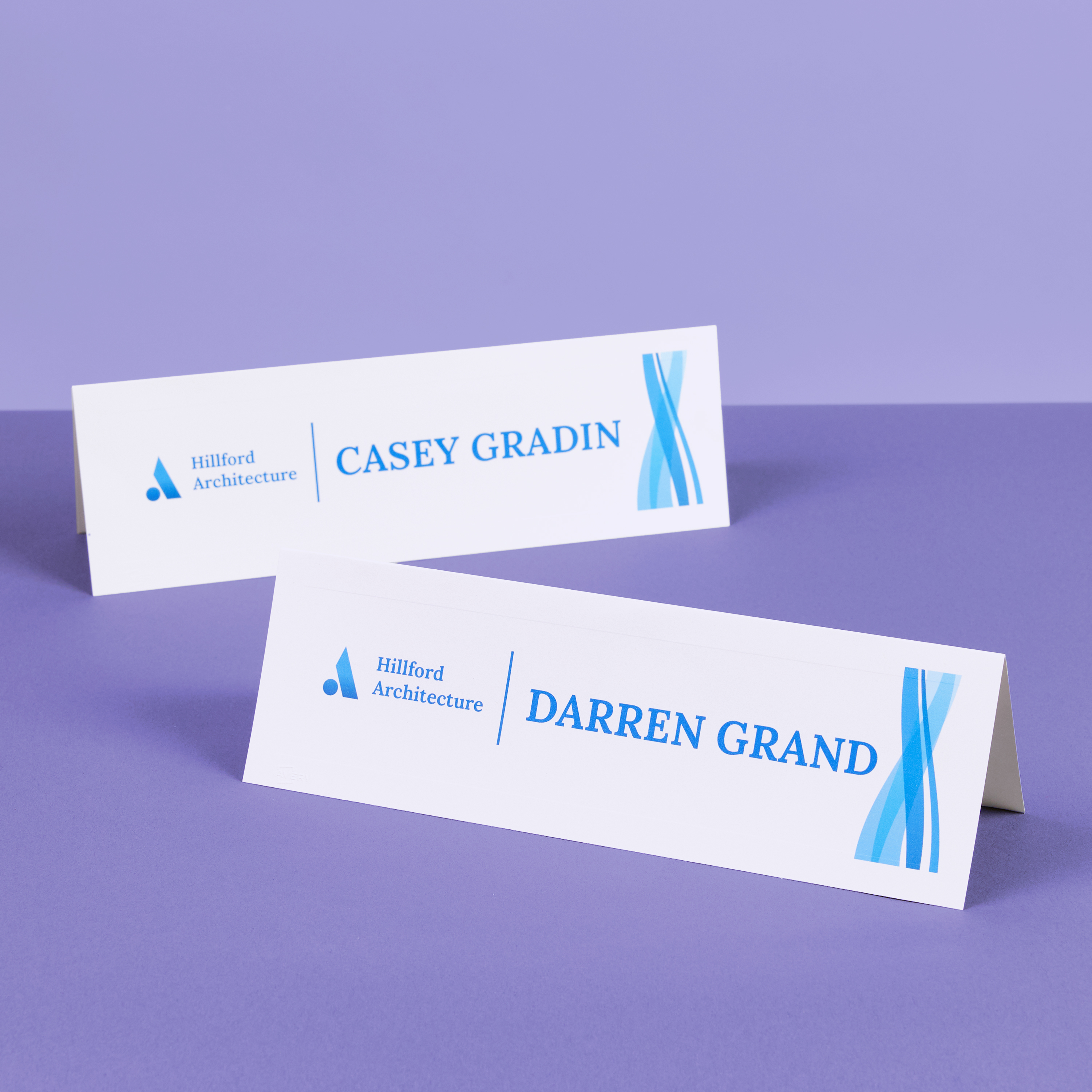 Two white tent cards on a purple background displaying names “Casey Gradin” and “Darren Grand,” used for professional client introductions.