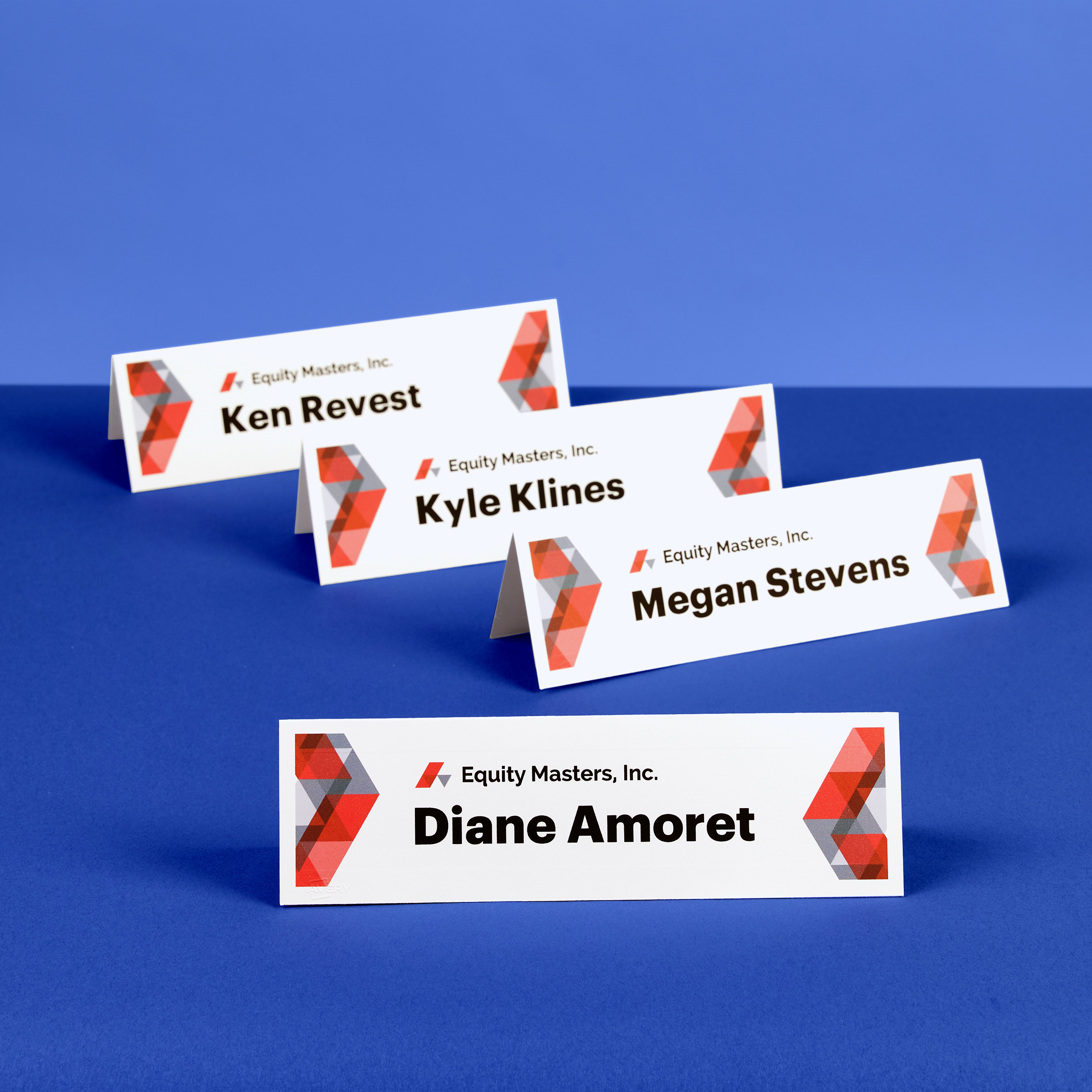 Tent cards labeled with speaker names on a two-tone blue background, showing how small business marketing tools support professional event setups.