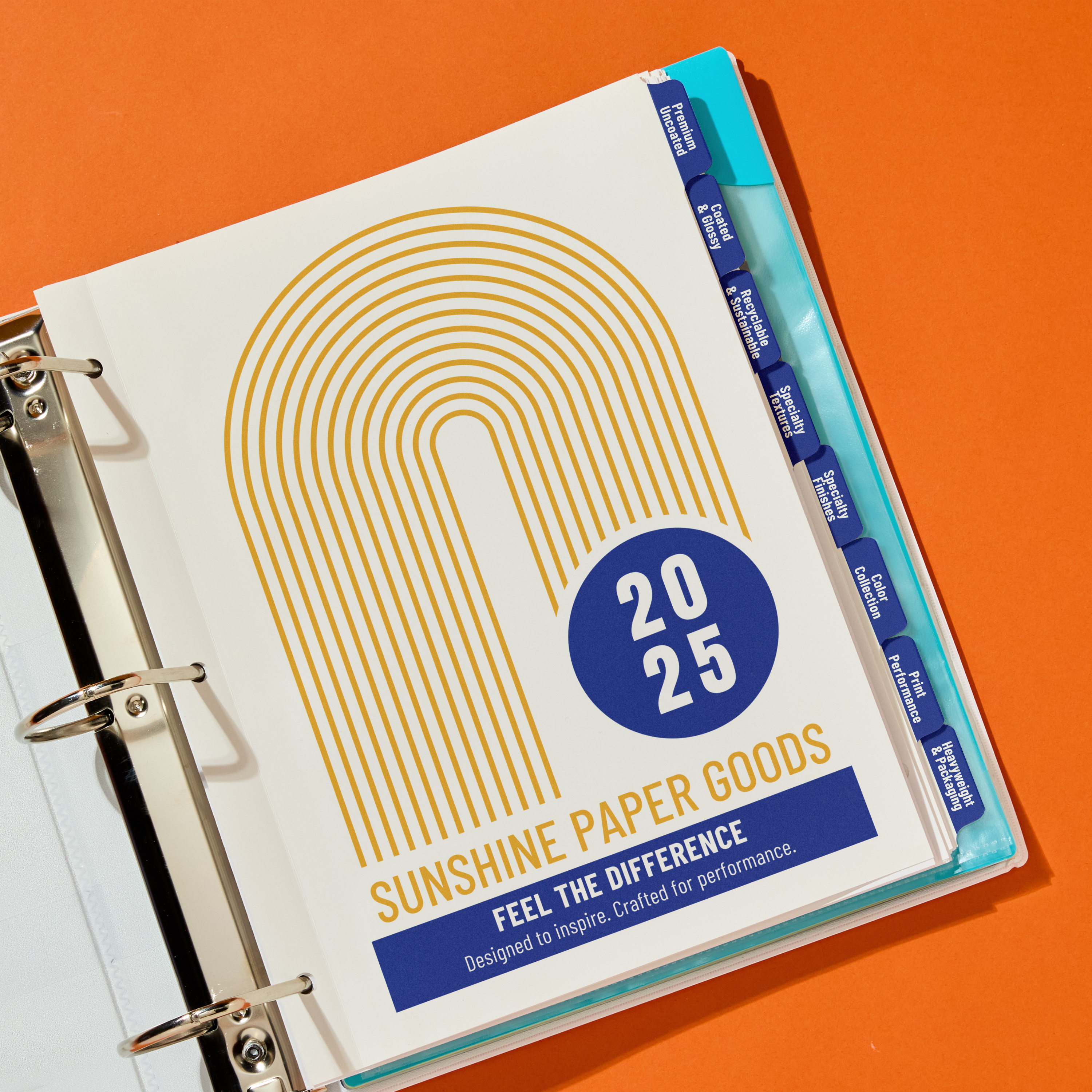 Open binder with a “Sunshine Paper Goods” cover page and custom printed tab dividers, organized by color on a bright orange background.