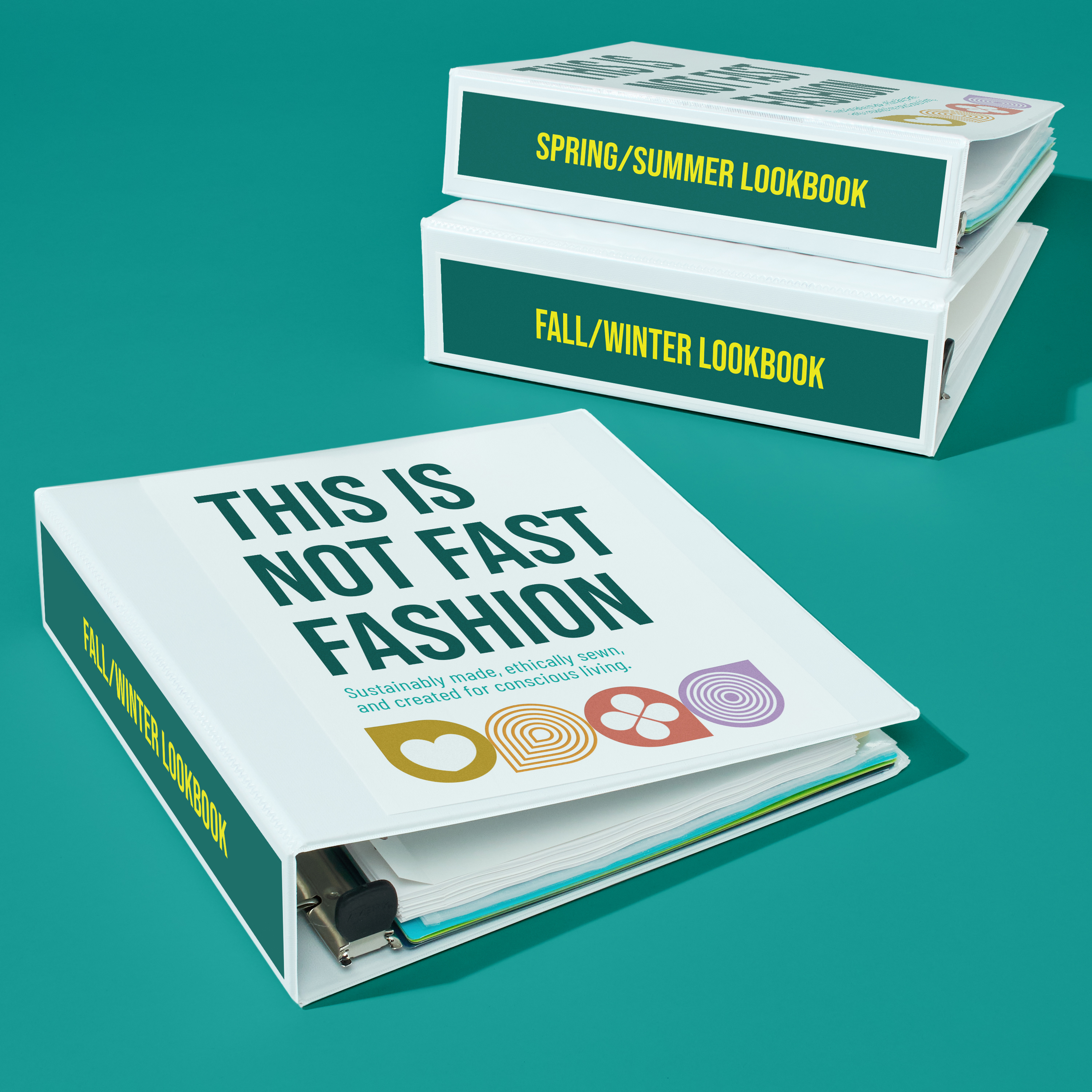 Three binders labeled “Spring/Summer Lookbook,” “Fall/Winter Lookbook,” and “This Is Not Fast Fashion,” shown as small business marketing tools for seasonal product presentations.