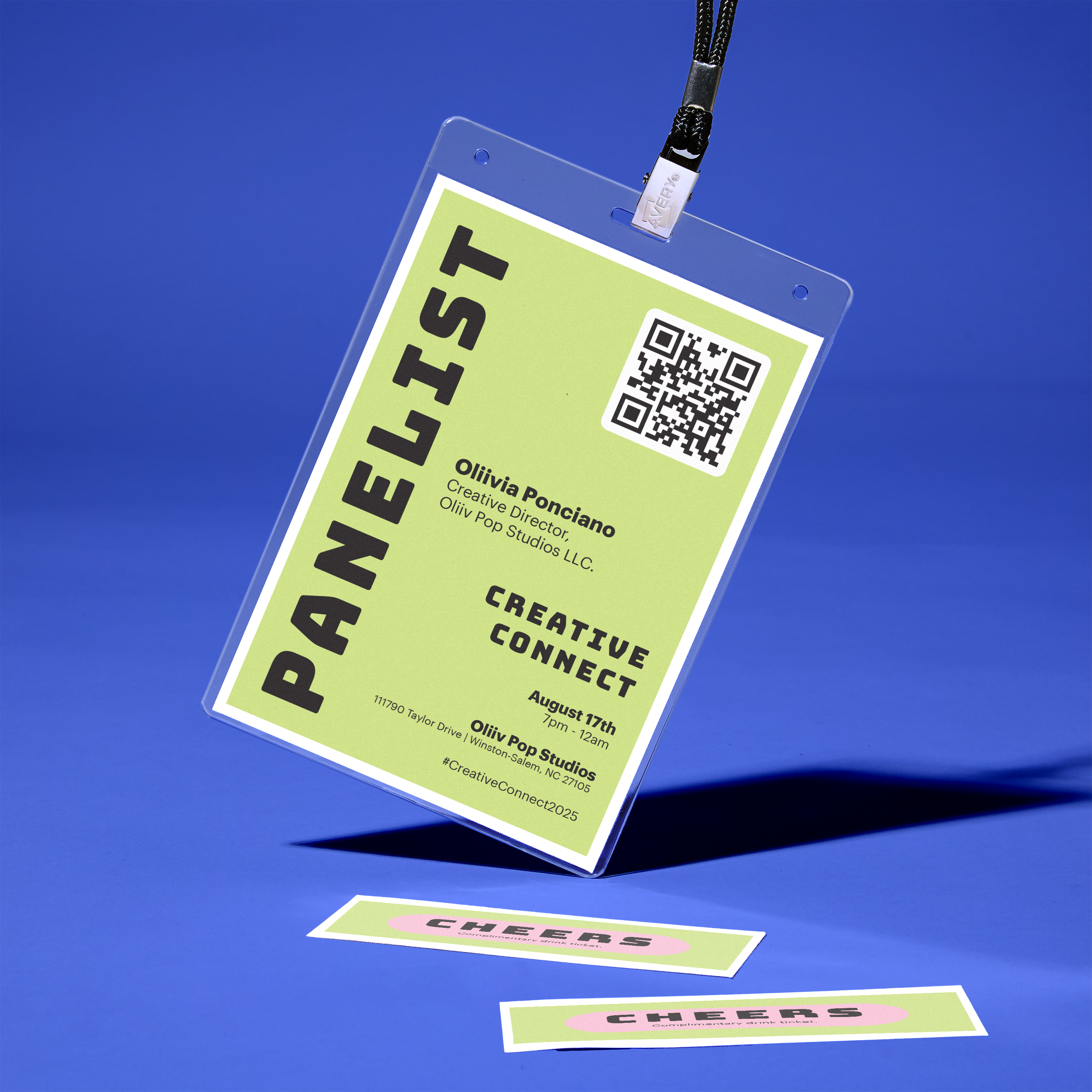 A bright, modern name badge for a panelist at the “Creative Connect” event. The badge is displayed in a clear plastic holder with a black lanyard, floating against a bold blue background. The design features a lime green background with black text that reads “PANELIST” vertically on the left, and includes a QR code, the name “Olivia Ponciano,” her company “Olivia Pop Studio LLC,” and event details. Below the badge are three small rectangular stickers that say “CHEERS” in pink and red on the same lime green background.