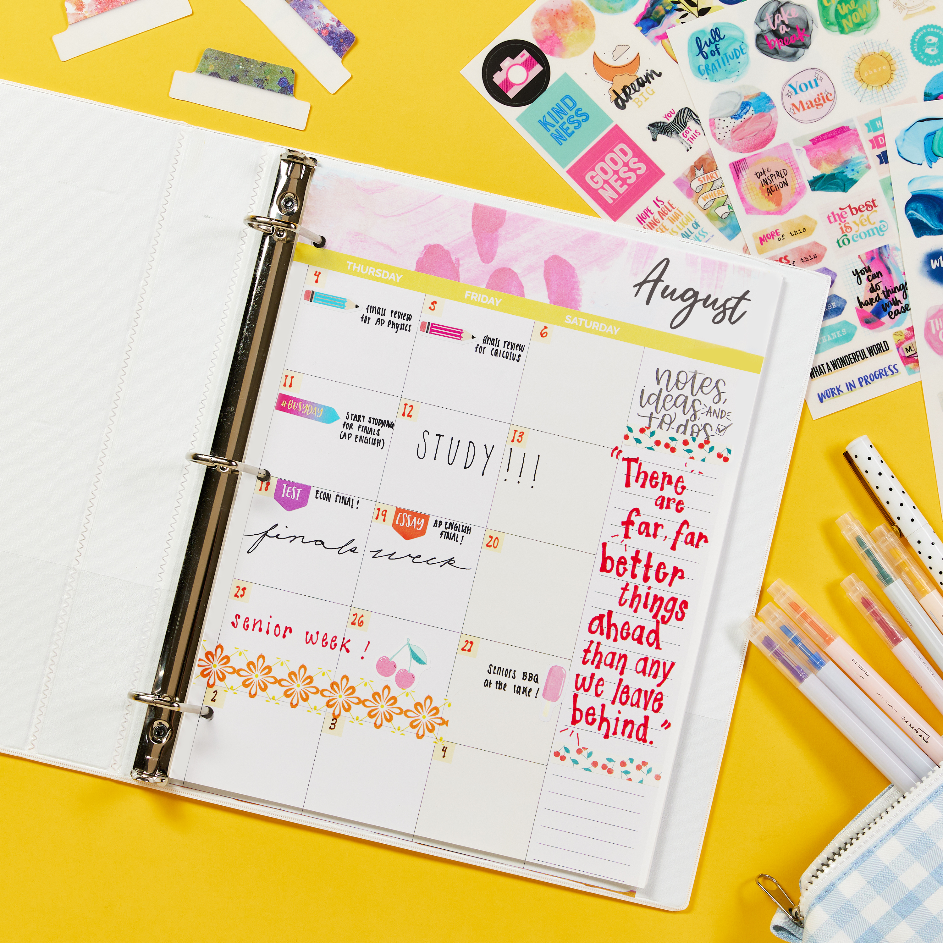 This image shows an example of DIY student planner made with Avery 1.5 inch binder 79795. The binder is laid open on a yellow background and surrounded by Avery Ultra Tabs, planner stickers and markers. Inside the binder are printed planner sheets.